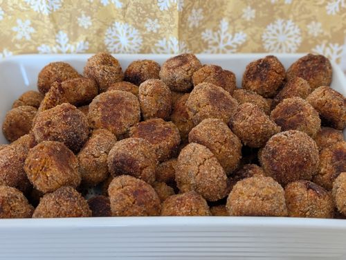 Ein Teller voll mit Linsenbällchen. In einem davon steckt ein Fonduespieß