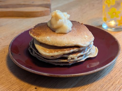A stack of pancakes with a dab of apple sauce on top